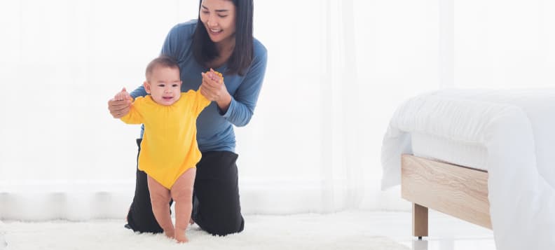 Mother helping her toddler to walk